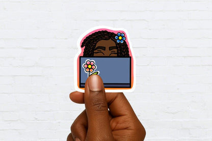 Sticker of a black woman behind a computer screen with flowers held by a hand against a white brick wall background