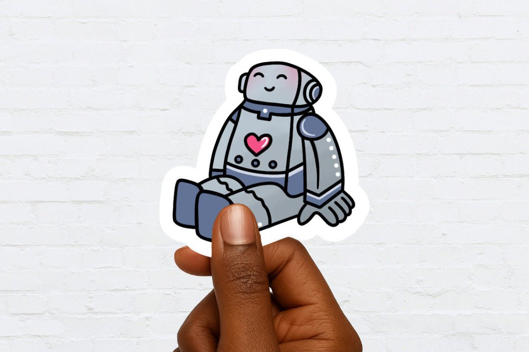 Hand holding a sticker of a robot with a heart on a white brick wall background