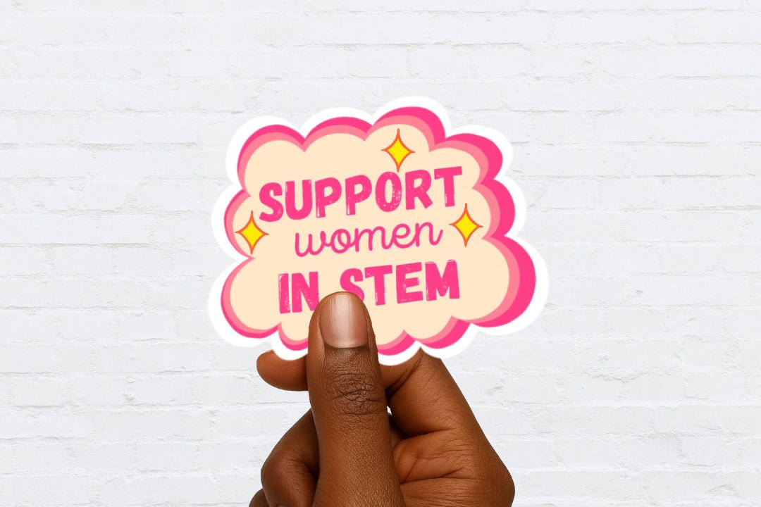Hand holding a sticker with 'Support women in STEM' text on a white background