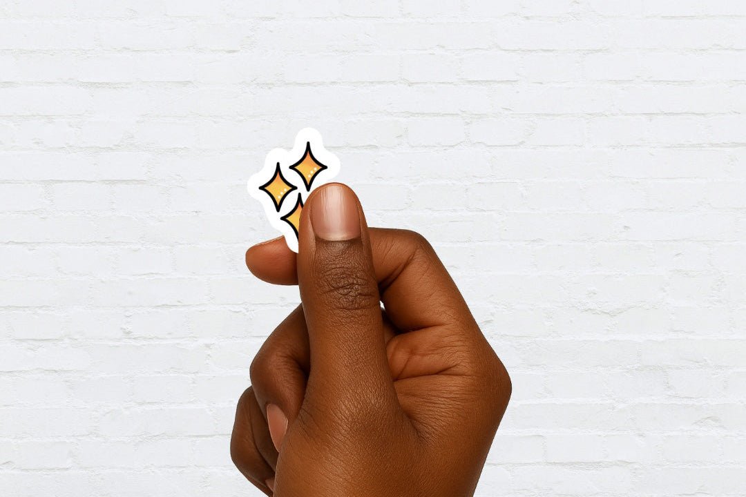 Hand holding a sticker of 3 stars against a white brick background