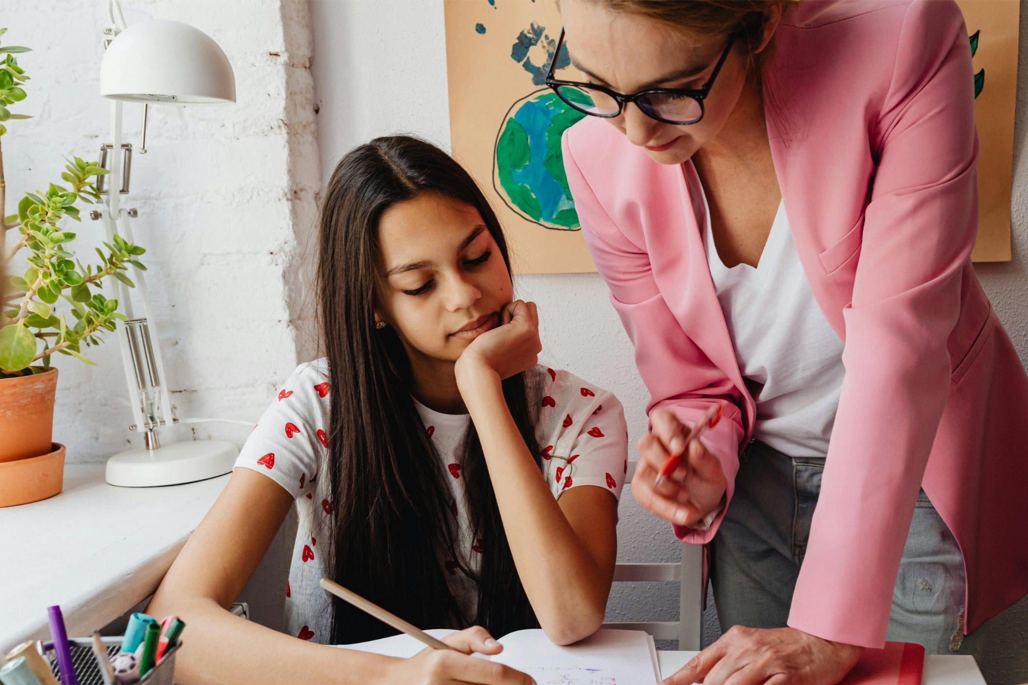 Teacher helping a student with homework in a classroom setting